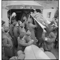 Des soldats français embarquent un blessé de circonstance à bord d'une ambulance (immatriculée M-50498) de la section sanitaire de volontaires américains (SSVA).