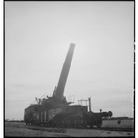 L'obusier de 400 mm de l'ALVF (artillerie lourde sur voie ferrée), baptisé maréchal-des-logis Lebeau, sur son affût-truck à berceau est photographié en plan général en contre-jour.