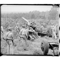 Des soldats anglais mettent batterie un canon de 155 mm M1.