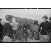 Canonniers servants d'un canon de 75 mm antiaérien camouflé, baptisé Yser, affecté à une batterie d'artillerie de défense côtière de la Marine nationale sur le littoral.
