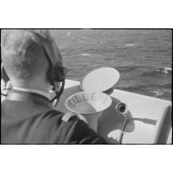 Un officier de quart de veille à la passerelle transmet des informations au poste de commandement du croiseur léger la Marseillaise.