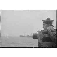 Caméramans du service cinématographique de la Marine (SCA/Marine) en tournage avec une caméra Debrie à bord d'un navire de la Marine nationale.