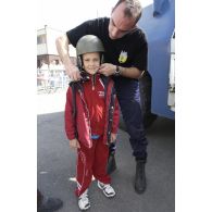Un gendarme de l'escadron 14/1 équipe un enfant lors de la démonstration de la gendarmerie de Satory.