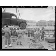 Déchargement d'un véhicule militaire d'un LSt (Landing Ship Tank) sur le port d'Alger par la Marine Nationale.