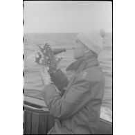 A bord d'un dragueur de mines de la classe 1940, un capitaine (Kapitänleutnant) utilise un sextant.