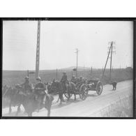 Un attelage hippomobile tracte un canon de 75 mm modèle 1897 sur une route.