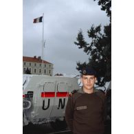 Portrait d'un caporal du 1er régiment d'infanterie de marine (1er RIMa) devant des véhicules de l'avant blindés (VAB) aux couleurs de l'ONU garés dans la cour de la caserne d'Angoulême.