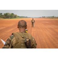 Soldats du 25e RGA du détachement logistique du GTIA (groupement tactique interarmes) Turco, mesurant au moyen d'un théodolite et d'une mire topographique le niveau du sol de la piste de l'aérodrome de la POD (plateforme opérationnelle défense) de Bambari, lors des travaux d'entretien à effectuer.