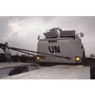 Chargement d'un véhicule de l'avant blindé (VAB) aux couleurs de l'ONU destiné à l'ex-Yougoslavie sur un camion spécial à plateau.