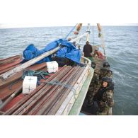 Des pêcheurs clandestins remontent leur filet de pêche supervisés par l'équipe de visite de La Gracieuse, en Guyane française.