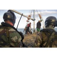 Des pêcheurs clandestins remontent leur filet de pêche supervisés par l'équipe de visite de La Gracieuse, en Guyane française.