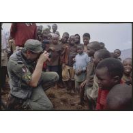 Opérateur de prises de vue de l'Etablissement cinématographique et photographique des armées photographiant un groupe d'enfants rwandais dans le camp de Nyacyonga.