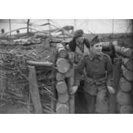 Deux soldats du 35e RI sortent d'une casemate de campagne enterrée.