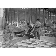 Plan général des fours de la boulangerie militaire autour desquels des boulangers s'affairent.