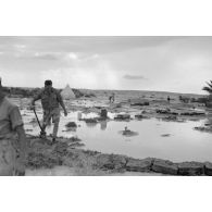 Armés de pelles, les hommes tentent de créer des digues pour limiter l'inondation de leur camp par les eaux de pluie.