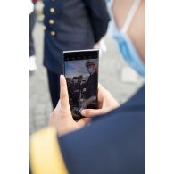 Un élève de l'école de maistrance prend en photographie avec son téléphone ses camarades pendant les derniers préparatifs avant le défilé à pied du 14 juillet sur la place de la Concorde.