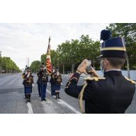 Un élève de l'école des officiers de la gendarmerie nationale (EOGN), prend en photo la garde au drapeau de son école lors des derniers préparatifs avant la cérémonie du 14 juillet sur les Champs-Elysées.