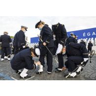 Derniers préparatifs pour les élèves de l'école navale qui ajustent leurs guêtres avant la cérémonie du 14 juillet sur la place de la Concorde.