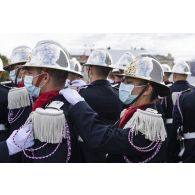 Derniers préparatifs pour un élève de l'école nationale supérieure des officiers de sapeurs-pompiers (ENSOSP) qui ajuste le col de son camarade avant la cérémonie du 14 juillet sur la place de la Concorde.
