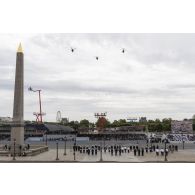 Défilé aérien d'un hélicoptère de transport Caiman et de deux Cougar de l'aviation légère de l'armée de Terre (ALAT) au-dessus de la place de la Concorde lors de la cérémonie du 14 juillet 2020.