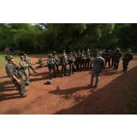 Un instucteur du 3e régiment étranger d'infanterie (3e REI) dirige un briefing auprès de stagiaires avant un exercice au centre d'entraînement en forêt équatoriale (CEFE) à Régina, en Guyane française.