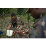 Un marsouin du 9e régiment d'infanterie de marine (9e RIMa) utilise un téléphone satellite pour contacter son commandement lors d'une patrouille à Maripasoula, en Guyane française.