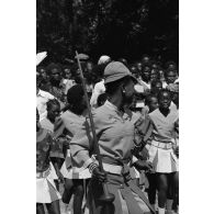 Défilé d'un groupe folklorique féminin zaïrois en l'honneur des troupes françaises, pendant la cérémonie militaire à Lubumbashi. <br>[Description en cours]
