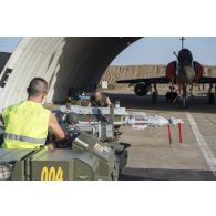 Des mécaniciens armement opérationnel montent des bombes GBU 49 sur un avion Mirage 2000D de l'escadron de chasse 1/3 Navarre à N'Djamena, au Tchad.