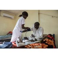 Une infirmière prend la tension d'un patient au pôle de santé unique (PSU) de N'Djamena, au Tchad.