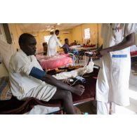 Une infirmière prend la tension d'un patient au pôle de santé unique (PSU) de N'Djamena, au Tchad.