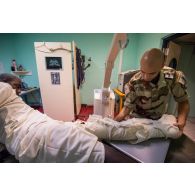 Un technologue en imagerie médicale prépare un patient pour une radiographie de la jambe au pôle de santé unique (PSU) de N'Djamena, au Tchad.