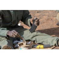 Un soldat malien recharge son fusil d'assaut AKM pour une formation de moniteur de tir à Gao, au Mali.