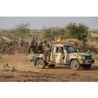 Des soldats maliens progressent à bord de leur pick-up sur la piste d'Ansongo, au Mali.