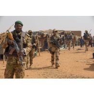Des soldats maliens accompagnés du détachement de liaison et d'appui opérationnel n° 3 (DLAO) patrouillent au grand marché de Tamkoutat, au Mali.