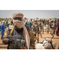 Un soldat malien accompagné du détachement de liaison et d'appui opérationnel n° 3 (DLAO) patrouille au grand marché de Tamkoutat, au Mali.