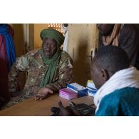 Un chef de section malien discute avec le médecin du centre de santé communautaire (CESCOM) de Tamkoutat, au Mali.