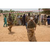 Des soldats français et maliens transportent un habitant par brancard au centre de santé communautaire (CESCOM) de Tamkoutat, au Mali.