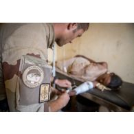 Un membre de l'équipe médicale du détachement de liaison et d'appui opérationnel n°3 (DLAO) réhydrate une femme enceinte au centre de santé communautaire (CESCOM) de Tamkoutat, au Mali.
