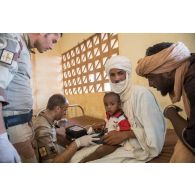 Un membre de l'équipe médicale du détachement de liaison et d'appui opérationnel n°3 (DLAO) ausculte un enfant au centre de santé communautaire (CESCOM) de Tamkoutat, au Mali.