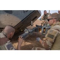 Des mécaniciens fixent le treuil d'un camion lourd de dépannage (CLD) à un véhicule de l'avant blindé (VAB) Ultima à Tamkoutat, au Mali.