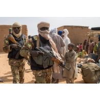 Des soldats maliens patrouillent au grand marché de Tamkoutat, au Mali.