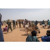Des combattants du groupe d’autodéfense touareg Imghad et alliés (GATIA) patrouillent aux côtés du détachement de liaison et d'appui opérationnel (DLAO) au grand marché de Tamkoutat, au Mali.