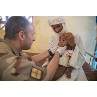 Un membre de l'équipe médicale du détachement de liaison et d'appui opérationnel n°3 (DLAO) ausculte un enfant au centre de santé communautaire (CESCOM) de Tamkoutat, au Mali.