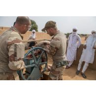 Des éléments du détachement de liaison et d'appui opérationnel n°3 (DLAO) aidés d'un soldat malien réparent le puits de Tamkoutat, au Mali.
