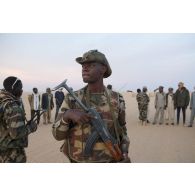 Un soldat nigérien sécurise le périmètre lors d'une interception d'orpailleurs sur la piste transsaharienne au Niger.