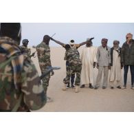 Des soldats nigériens fouillent des orpailleurs interceptés sur la piste transsaharienne au Niger.