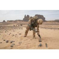 Un élément opérationnel de déminage (EOD) recherche des munitions éparpillées sur une zone minée au Niger.