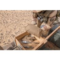 Un élément opérationnel de déminage (EOD) conditionne des munitions découvertes sur une zone minée au Niger.