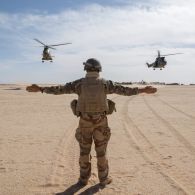 Un guideur aérien tactique avancé (GATA) guide le poser de deux hélicoptères Puma SA-330B du 3e régiment d'hélicoptères de combat (RHC) dans le secteur de Wour, au Niger.
