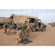 Des soldats montent l'antenne d'un véhicule léger de reconnaissance et d'appui (VLRA) moyen d’élongation pour les communications hautes fréquences interarmées et OTAN en réseau (MELCHIOR) pour installer un centre opérationnel (CO) sur l'axe Berliet, au Niger.